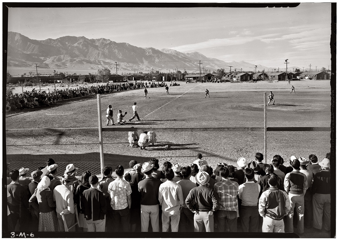 A baseball game against the backdrop of the Sierra Nevada at the Manzanar Relocation Center, 1943. View full size. Photograph by Ansel Adams.