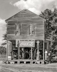 August 1936. "Crossroads store at Sprott, Alabama." 8x10 inch acetate negative by Walker Evans for the Resettlement Administration. View full size.
SprottI wonder if this is all there was to Sprott.
On the map, Sprott
Is just a dot.
Limerick contest!There was a young lady from Sprott ... 
How about thisThere was a gaunt yogi from Sprott
Who asked the boys, Am I not hot?
Whenever she lotused,
The boys winced and noticed,
And thought to themselves, "You are knot."
Part of This Place Still Standing?Check out this link for "Then and Now" photos of this scene:
http://www.marvhamm.com/my_family_page2.html
Great linkObviously not a lot has changed at that interchange over the years.
There once was a lady...There once was a lady from Sprott
Whose friends knew her simply as Dot.
When asked whence the label
She spawned a short fable
And replied "It's a sinister plot."
There once was a lady...Bravo!
My Mom, Eleanor MitchellMy Mom, Eleanor Mitchell Butler, and most of her brothers and sisters were born "in Sprott", up the dirt road from the store. Mom was born in 1918.
Coca-ColaAh, the good ol' days before that nasty stuff called Pepsi started creeping in...
More on SprottCheck this site for more pictures and info.
What was Sprott like?Curious about the background to this iconic photo of the general store. Can anyone name any of the specific people in that photo? What was this place like? Were most of the people that lived there Sharecroppers? I notice there are bars on the windows, was this a dangerous community? When was the little store built?
Finding RootsMy grandmother was born here in 1918 I believe. Her family name is Perry. I am looking for information about the city, possible familial connections still there and I am starting here. Anyone have any idea about where else I can look?
(The Gallery, Gas Stations, Rural America, Stores & Markets, Walker Evans)
