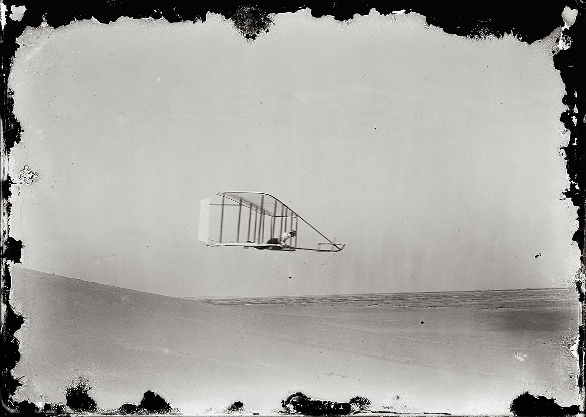 October 10, 1902. Kitty Hawk, N.C. "Wilbur gliding in level flight, moving to right near bottom of Big Hill." Glass negative by Orville Wright. View full size.
