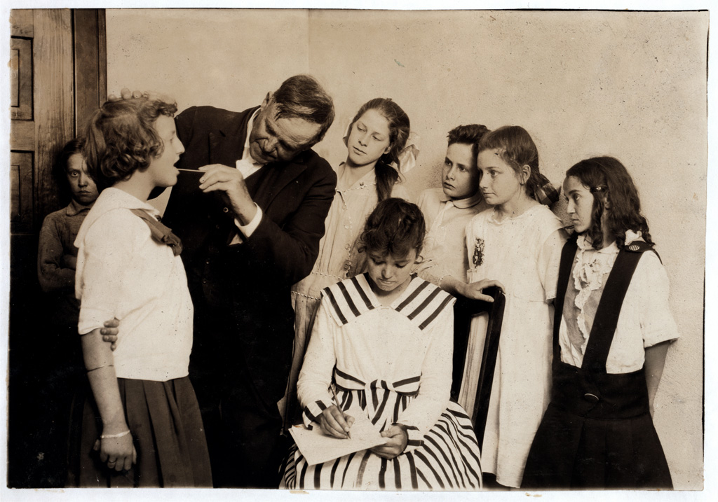 Students in grade 6 of Washington School in Lawton, Oklahoma, have their throats examined during a medical inspection. Photograph by Lewis Wickes Hine, 1917. View full size.