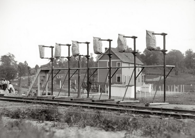 1912. "Post Office Department. Hupp Auto Railway Service" (i.e., Hupp Automatic Mail Exchange, a system for transferring mail bags to and from a moving train). Harris &amp; Ewing Collection glass negative. Note the two utility poles at left that have been scratched off the negative. View full size.
