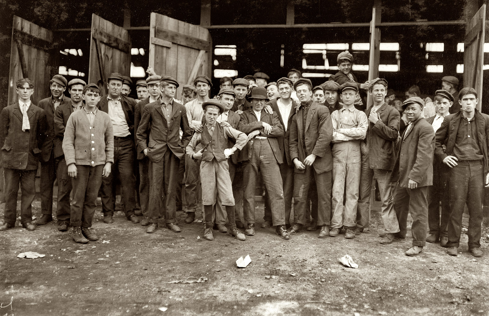Workers at the More-Jones Glass Co. in Bridgeton, N.J. Small boy in the middle is Harry Simpkins. The photograph is by Lewis Wickes Hine, who described the work conditions as, "dirty, noisome." November 1909. View full size.
