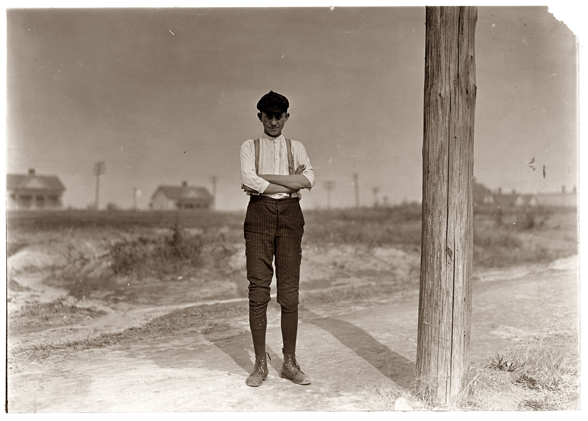 Bob Burton, Gastonia, North Carolina. 15 years old. A typical adolescent, overgrown, thin, anemic. Been in mill for 8 years. Doffing still in Ozark Mills. November 1908. View full size. Photograph by Lewis Wickes Hine.