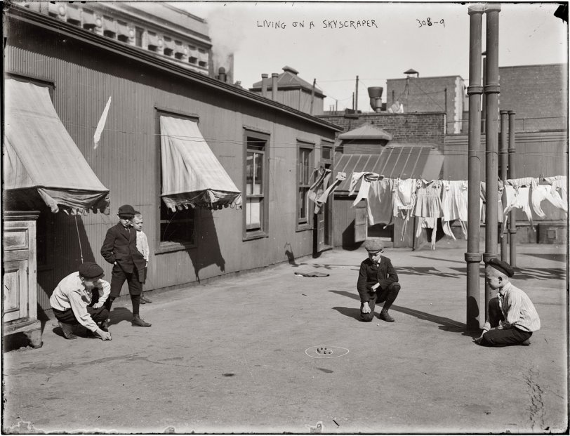 "Living on a Skyscraper." Boys playing marbles on the roof of a New York apartment building circa 1909. View full size. George Grantham Bain Collection.