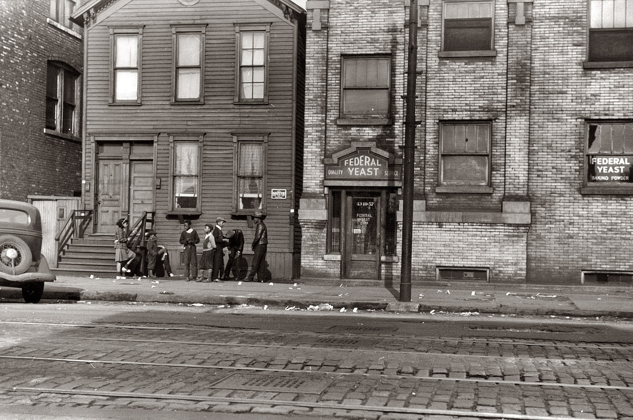 Chicago street scene, April 1941. Papers littering the sidewalk are "policy slips." ["Policy" was a lottery gambling system once common in some black communities.] View full size. 35mm nitrate negative by Edwin Rosskam.