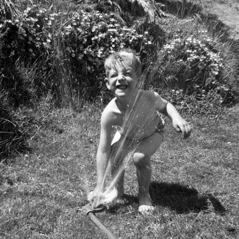 Well, hot summer weather has finally come to this part of Northern California, so it's time to haul out the lawn sprinkler and the kid and let 'er rip. Here in 1950 in our back yard in Idyllic Larkspur™, my sister is handling the camera and I'm handling the comedy. View full size.