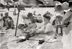 July 11, 1911. "On beach near Casino, Asbury Park." Anyone up for a nice cold lemonade? 5x7 glass negative, George Grantham Bain Collection. View full size.
It&#039;s the Dad!My guess is that the man smoking, looking disinterested in the children and clearly setting himself apart from the little ones, is of course, their father.  Who else could look so disengaged?
Hat manThe guy on the left seems a teensy bit overdressed.
The Butler did it!Who the heck is the creepy guy in the suit and tie?
&quot;The look&quot;The stare of the young lady -- straight on and unwavering!  Marvelous!
Gibson GirlyThose women have their arms bare all the way up to the elbows! What's next -- exposed ankles?
Sand paleIt would be some time until suntanned skin would be considered attractive on women. That was popularized by our old friend Coco Chanel, who also popularized extremely heavy smoking for women (she suggested 3 to 4 packs a day, to keep weight down). 
Very Now in a Then Sort of WayWith a change of costume but not necessarily much change in hairstyles, the two young women and their children can be seen in the same poses on any summer beach today (you won't even have to wait for summer here in San Diego where I'm writing), not to mention the boy behind them who's smiling as he notices the camera. I've an old friend who lived out here in the 1970s who looked quite like this girl and who frequently wore her long hair in the same Edwardian crown roll, and looked smashing in vintage shirtwaists with boned collars. Same thoughtful gaze, too, but I can't say that I remember her showing up on the beach in those shoes.
PainterlyFrom the composition to the use of lighting and shadow - add a few brush strokes and this is Renoir or Seurat.
MesmerizingI spent five minutes absorbing the details of this image.  I've always found the Gibson Girl look very fetching, and the young woman holding the child is, well, I'd love to meet her.  
Gosh, to know the whole story of this simple scene. Where and how they lived, what did they have for lunch, what happened at home that evening, or throughout the rest of their lives for that matter. These pictures resonate in some deep place for me and I'm sure many others.
Still waiting for that time machine.  Somebody, please hurry.
Que Seurat, SeuratI have to agree with T.U.M., it sure looks like it would make a perfect Seurat subject.  Hope the photoshop contest crowd gives it a shot.
P.S. -- The Jersey Shore still attracts some of the most attractive women in the world.  
A TuesdayA Tuesday if I remember correctly, around noon on a sunny summer day ... Just inspired me to write a story.
This is a remarkable photo.This is a remarkable photo. The ladies are lovely, the voyeur looks the same as he would today... The boy on the right in the seersucker suit looks as uncomfortable as can be.  I love this photo.
Heaven forbid!This really is a wonderful picture in so many ways. It's probably my all time favorite photo here on Shorpy. My take on the people follows:
The woman holding the little girl and saying something to the boy is their mother. The woman in the foreground is her sister and the other little girl is hers, the cousin of the boy and his sister.
As for that oddball in the straw hat being the boy's father, heaven forbid! At best I'll let him be the uncle, and even that's a stretch, although it would leave open the question of just who the heck he is. I'm tempted to Photoshop him out of this otherwise enchanting scene, but that would be "lying" and so I won't do it.
As Anonymous Tipster commented: Gosh, to know the whole story of this simple scene! If ever a time machine was needed, this is the moment!
Was this 1911 or 1908?I've just checked the Library of Congress website and the date given for this GG Bain photograph is July 19, 1908.
[The date (7-11-1911) is written on the edge of the negative. Someone seems to have confused it with the date written on this negative. - Dave]
Two very different daysThanks for the clarification! So it really was 7-11-1911, a Tuesday. In that other picture, the one dated 7-19-08, the surf is high and wild. Couldn't possibly have been taken on the same day as this placid "Seurat"-like scene.
Glad to know that Shorpy leaves no stone unturned to assure accuracy.
100 years ago todayand today is 7/11/11!
Stewed PrunesNothing screams beach outfit like an overcoat, shirt, tie, trousers, black socks and shoes.  Luckily, the straw hat deflects the 90 degree heat rising from the scorched sand preventing this hallucinatory individual from spontaneously combusting.  Later in the day, this gentleman was reported to be seen leaving the Casino wearing only his trousers and hat.  He immediately left Asbury Park, went home to find a wool suit and promptly returned to his spot on the beach.
(The Gallery, G.G. Bain, Sports)