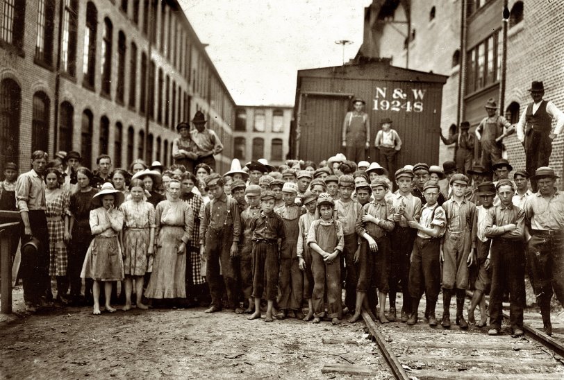 May 1911. Fries, Virginia. A part of the spinning force working in the Washington Cotton Mills. Group posed by the overseer. All work. The overseer said, "These boys are a bad lot." All were alive to the need for being 14 years old when questioned. View full size. Photograph and caption by Lewis Wickes Hine.

