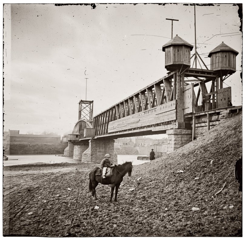 Fortified railroad bridge across the Cumberland River at Nashville, 1864. "Continuing his policy of the offensive at any cost, Gen. John B. Hood brought his reduced army before the defenses of Nashville, where it was overthrown by Gen. George H. Thomas on December 15-16, in the most complete victory of the war. If the date borne on this photograph is correct, it was taken in the course of the battle." View full size. Wet collodion glass stereograph by George N. Barnard.

