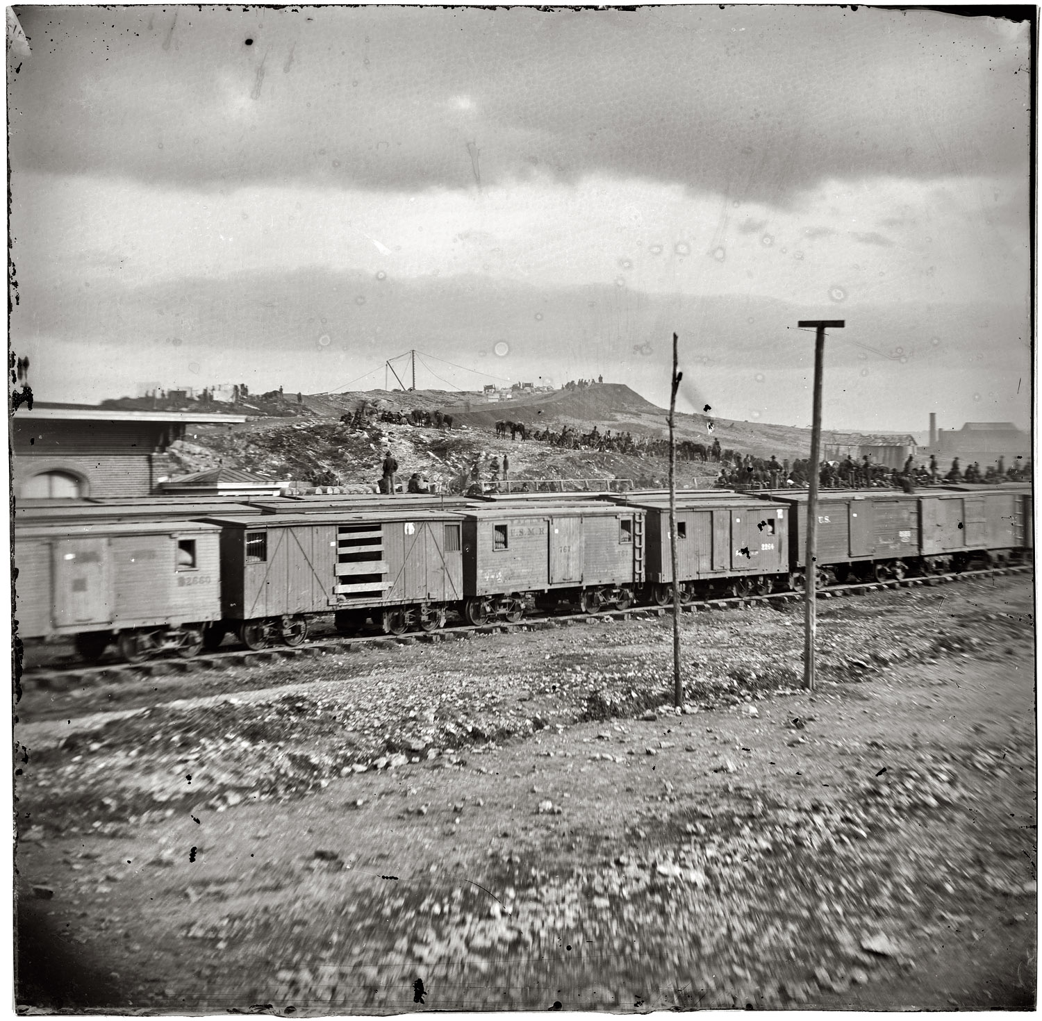 1864. Chattanooga, Tennessee. "Boxcars and depot with Federal cavalry guard beyond. From photographs of the War in the West. Battle of Chattanooga, September-November 1863. Photograph probably taken the following year, when Chattanooga was the base for Sherman's Atlanta campaign." Wet plate glass negative, half of stereo pair, photographer unknown. View full size.
