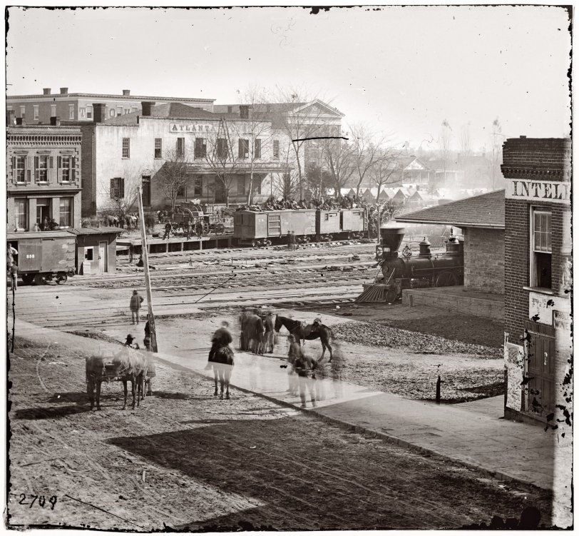 Union soldiers on boxcars at railroad depot next to offices of the Atlanta Intelligencer during the city's occupation by General Sherman. View full size. Wet plate glass negative by George Barnard. Alternate view here.