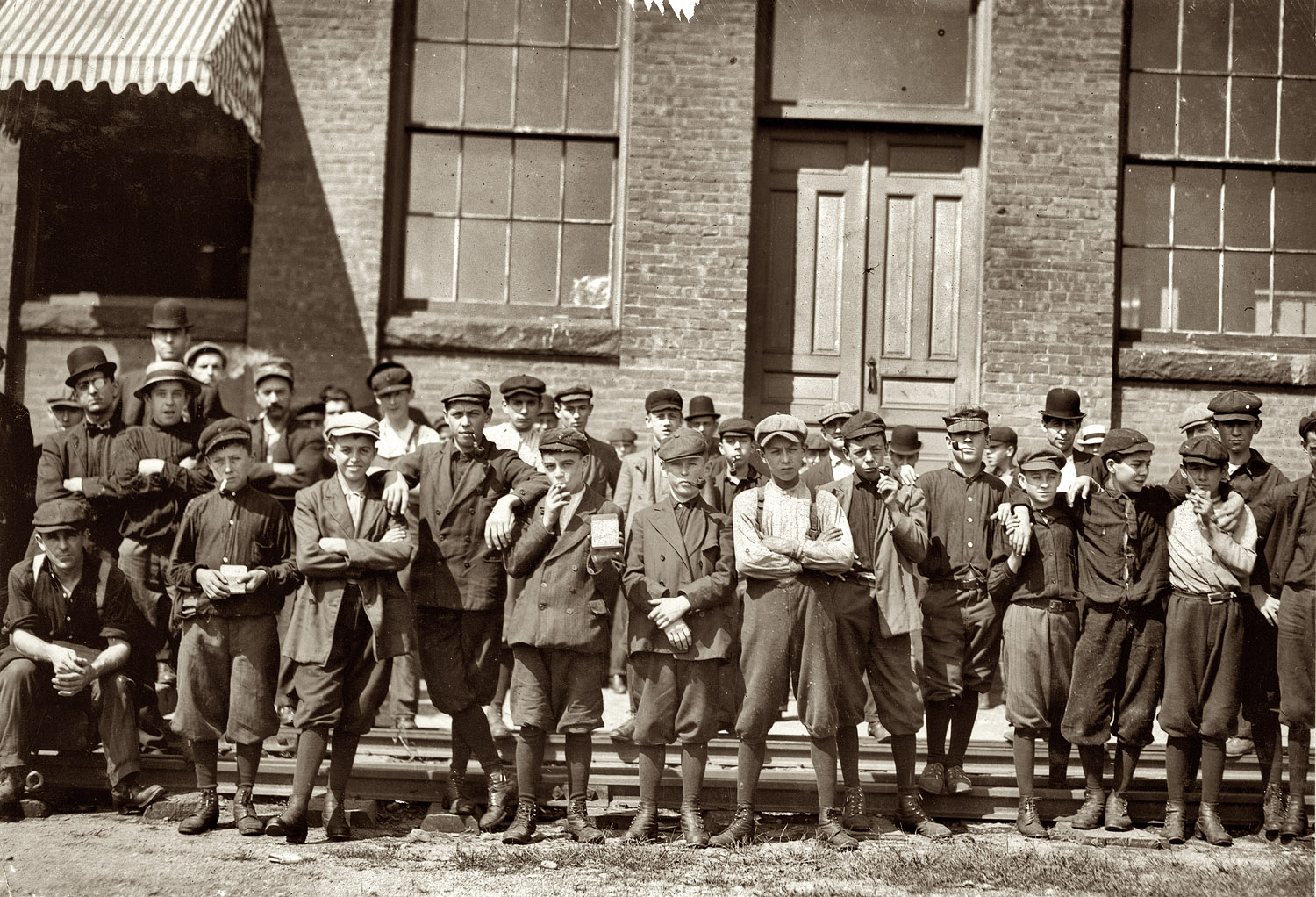 Group in front of Indian Orchard Mfg. Co. Everyone in photo was working there. Boy not photographed: Hector Dubois, 24 Water St., doffer who crushed finger in pump. Indian Orchard, Massachusetts. September 1911. View full size.