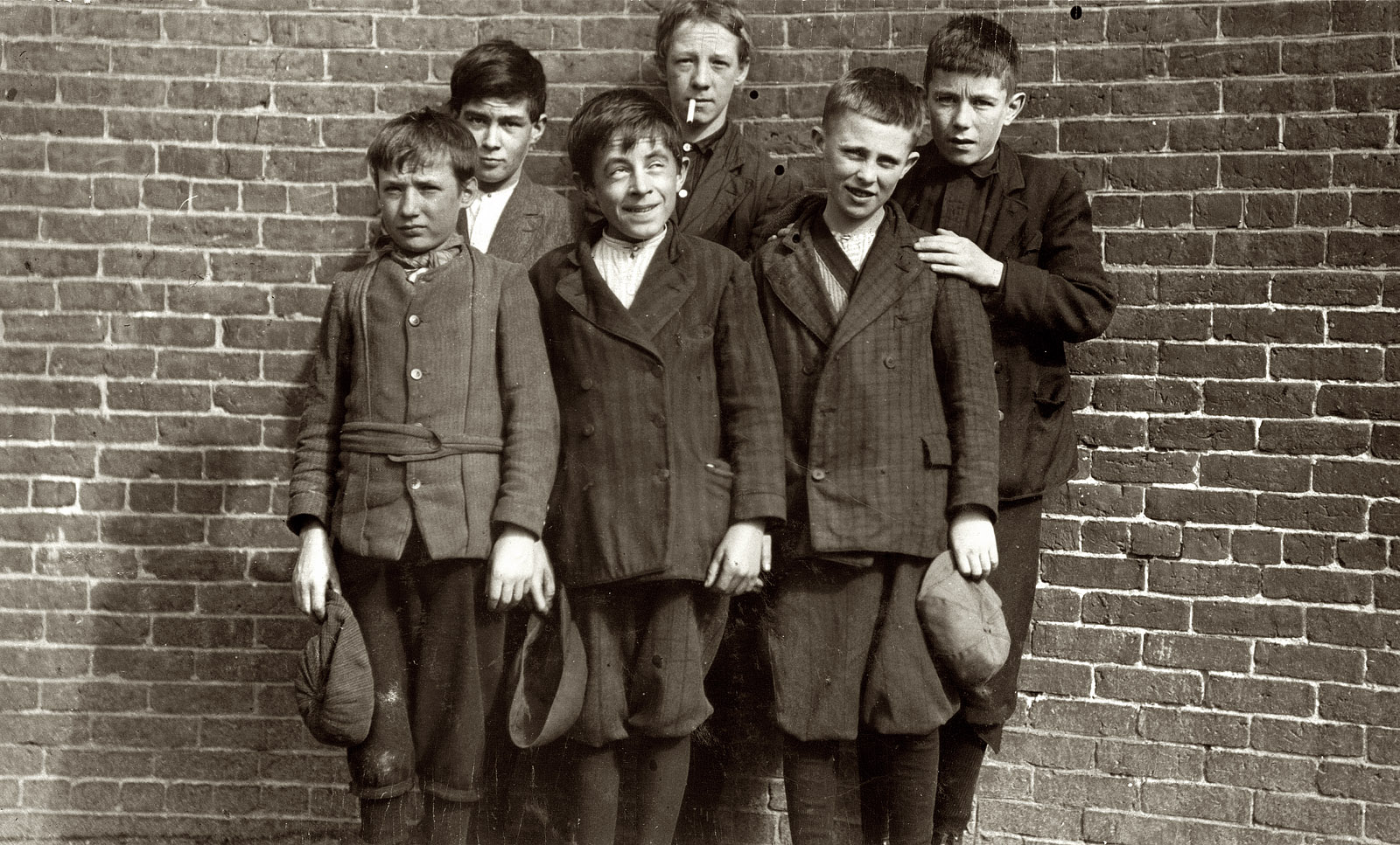 October 1911. Vicinity of Lowell and South Framingham, Mass. Merrimac Mill boys. Front row: Smallest, Robert Magee, 270 Suffolk Street; John Neary, 211 Lakeview Avenue; Michael Keefe, 32 Marion Street. Back row: Edward Foster, 40 Fulton Street; John Risheck, 391 Adams Street; Cornelius Hurley, 68 Adams Street, No. 1 mill room. View full size. Photograph by Lewis Wickes Hine.