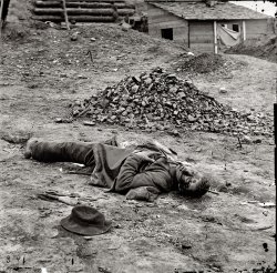 April 1865. Petersburg, Virginia. "Dead Federal soldier." Wet plate glass negative, right half of stereo pair, by Thomas Roche. Library of Congress. View full size.
So sadGrowing up my dad was a big civil war buff and we visited all the battlegrounds. It was so peaceful and green but still sad. These pictures help bring home the realities of war. So many people lost. Does anyone know what that is next to him, with perhaps his initials on it? 
[It's a leather satchel with the "U.S." insignia of the Army. - Dave]
The satchel is...The satchel is cartridge box.  They were often issued with a
brass plate with the "US" or occasionally a state insignia. 
Confederate soldier This was actually a rebel soldier killed at Ft. Mahone.  Hit in the head by shrapnel.  There are several other views of the same body where the photographer places props such as headgear and an artillery sponge around him.  He was wearing U.S. Army belts which were probably taken from a Federal prisoner.  April 3, 1865
(The Gallery, Civil War, Thomas Roche)
