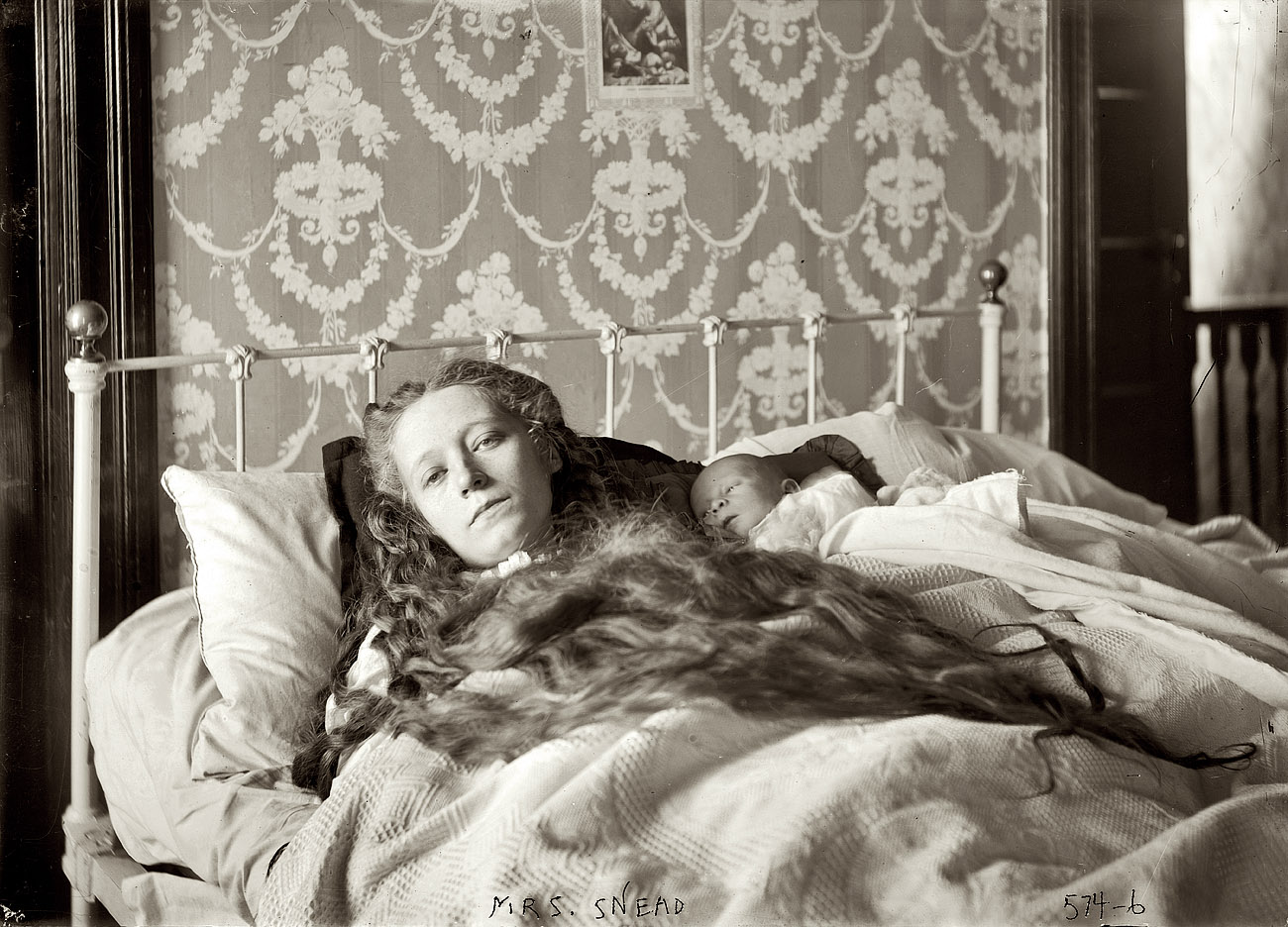 "Mrs. Ocey Snead, in bed, baby in arms," December 1907 or January 1908. 5x7 glass negative, George Grantham Bain Collection. View full size. Ocey, who was found dead in an East Orange, New Jersey, bathtub in November 1909, drugged and emaciated, was at the center of scandalous murder case involving her mentally unbalanced mother and a spinster aunt who starved herself to death while awaiting trial. Along with a third sister they were thought to have conspired to drug and starve Ocey to collect $32,000 in insurance money. Ocey had two children, one of whom died in infancy. (Coverage in the New York Times noted the discovery of small bones in the furnace at a building where Ocey lived -- a Brooklyn tenement dubbed "house of mystery" and "baby farm" by the neighbors.) One part of the mystery is how two photographs of Ocey, very much alive, ended up in Bain News Service collection of glass negatives at the Library of Congress. (The other photo is dated 12-21-07). Are they are family photos obtained in the course of covering the trial of the sisters? Or is there some reason GGB would have photographed Ocey well before she died? (Cue organ music.)