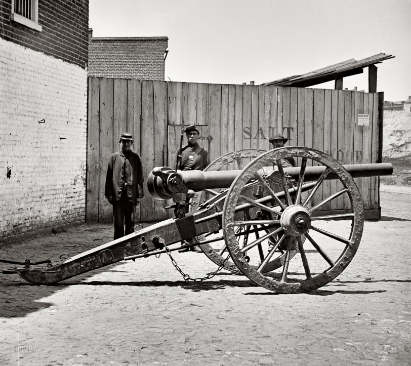 April 1865. Richmond, Virginia. "Federal soldier guarding Whitworth gun on wharf awaiting shipment." Wet plate glass negative. View full size.
