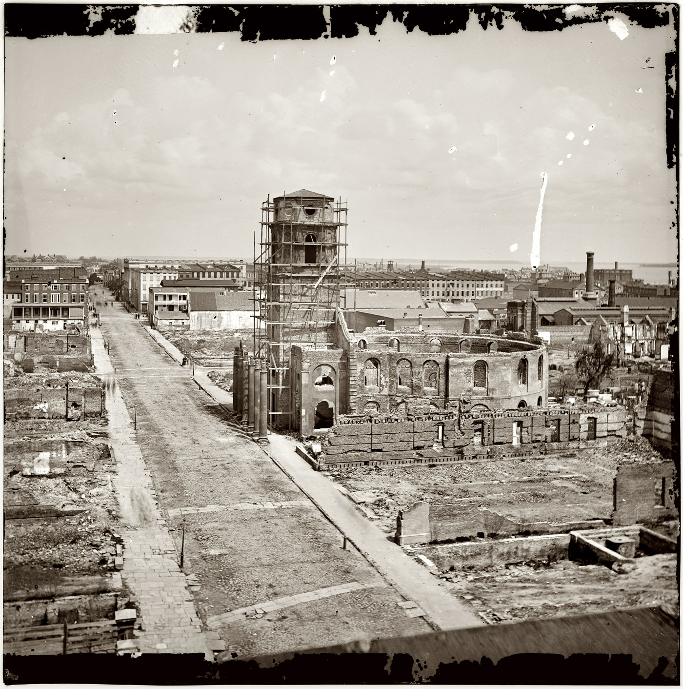 April 1865. Charleston, South Carolina, after bombardment by the Federal Navy. View from roof of the Mills House, looking up Meeting Street at ruins of the Circular Church, damaged in an 1861 fire. View full size. This is the scaffolded building seen in last week's Civil War posts. From photographs of the Federal Navy and seaborne expeditions against the Atlantic Coast of the Confederacy, 1863-1865. Right half of a wet-plate glass negative stereograph. Of interest is the faint registration of clouds, which I've brought out with the Shadows & Highlights filters in Photoshop. Most daytime outdoor photography from the 19th century shows blank white skies, a common characteristic of the blue-sensitive emulsions used in the days before panchromatic black-and-white emulsions came into use.