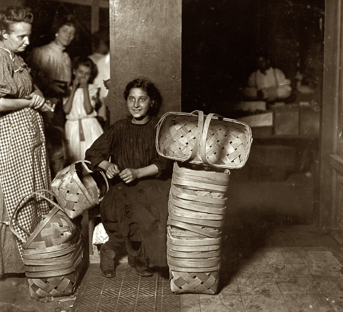 August 1908, Cincinnati. "Lena Lochiavo, 11 years old, Basket Seller, Sixth Street Market. Saloon entrance. 11 p.m. Had been there since 10 a.m. and not yet sold out." Photograph and caption by Lewis Wickes Hine. View full size.