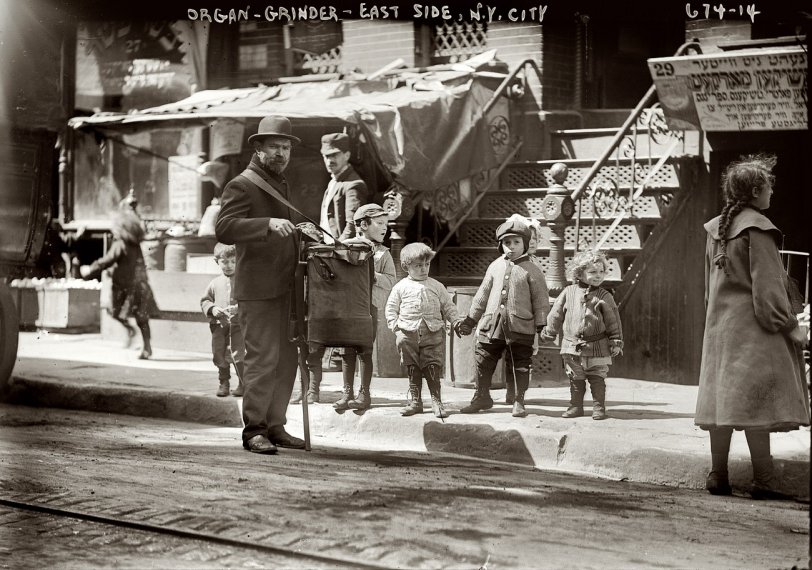Photo of: The Organ Grinder: 1910 -- An organ grinder on the streets of New York's Lower East Side circa 1910. 5x7 glass negative, George Grantham Bain Collection. View full size.