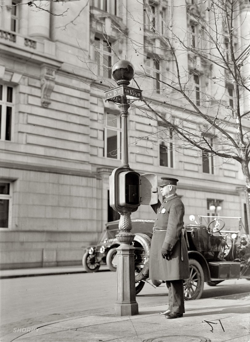Washington, D.C., circa 1912. "Police Call Box." Finally we have a closeup of a mysterious item of street furniture on view in many of our urban scenes -- what looks like a streetlight with a dark globe. These were telephones with a direct line to the police station. When a call went out, the red illuminated globe showed arriving officers where help was needed. This one was downtown at 13½ and D streets N.W. Harris &amp; Ewing Collection glass negative. View full size.
