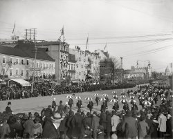 March 4, 1901. "President William McKinley second inaugural parade, Pennsylvania Avenue." Brady-Handy Collection glass negative. View full size.
Precision Umbrella Drill Team Rules!Complete with snappy white top hats (the Doo Dah Parade is calling, gentlemen!) And if that's The Washington Post building in the background, maybe they're the (well informed) destination for the impressive array of phone lines above the buildings on the left. Hopefully the men perched atop the other phone pole aren't disrupting calls!
Just funWhat a whimsical sight, from the umbrellas, to the white top hats, to the dog in the street. Can you think of any inaugural parade in the last fifty years that was as much fun?
Friends ForeverIs that a pickpocket in action left foreground?
MulletDid anyone else notice the fashion-forward hairdo on one member of the umbrella drill team?
Takes GutsThere are at least 2 men sitting on top of a telephone or light pole and a few more about halfway down. I hope they all got down safely.
DisneyesqueIt looks like it was staged by Walt Disney and great fun to be in and to watch.  One of the aspects of "the good old days" that is actually true: no fears of disruption or calamity.  A celebration of Liberty.
No dames allowed?Virtually no women visible in the ranks of the spectators. What's that about?
[There are dozens of women in this picture. - Dave]
What goes up must come... Wait, what?Again and again, we see photos on Shorpy that feature people fearlessly leaning out 6th-floor windows, cramming onto roofs, perched on mile-high balconies and swinging from the tops of fifty-foot poles.  Makes me think the apple fell on Isaac Newton much later...say, the 1940s.
Pride ParadeThe umbrella corps would do San Francisco proud. Not that there's anything wrong with that.
Where&#039;s Waldo......can you find at least one man who is uncovered (not wearing a hat)? I think I can see a couple.
I find it heartening to see such enthusiasm for the workings of democracy. I suppose a cynic would say that it was a time when the people were starved for entertainment and would turn out for any dog and pony show, especially if given a few hours off. To me, in a time when the media weren't so pervasive, it was probably important that the democratic process was proved to have been completed.
A Prelude>> One of the aspects of 'the good old days' that is actually true: no fears of disruption or calamity.
That's a rather ironic statement considering that slightly less than 6 months later the man whose inauguration was being celebrated would lie dead in Buffalo, shot by the Anarchist Leon Czolgosz.
The VillageAnyone else see the umbrellas and capes and think of The Prisoner?
Short TermMcKinley, the last veteran of the American Civil War to be elected, would be assassinated six months later. His vice president, Theodore Roosevelt, would succeed him. 
Number 2I thought of The Prisoner too.
Short Time in OfficeFrom the date of this photo, President McKinley would have but a little more than six months in office; losing his life to a madman's bullet on September 14th. His VP - Teddy Roosevelt would become the 26th President.
I agree that this looks to be a much more enjoyable inaugural parade than we've seen of late. I doubt that any of these marchers would be thrown out of their organization because they dared look at the President.
Social ProprietyOnce past the Umbrella Drill Team, one is impressed that onlookers are free to line buildings, windows and parapets. Although there is some police presence, it appears nobody really expects this important ceremony to be disrupted by protests or violence. No longer a safe assumption in these security-conscious days! Still, the price of this social stability seems to have been a rigid sense of "proper" dress and public decorum.  One might wish to stroll down lovely Tremont Street in 1906 Boston, but imagine having to dress up like this just to go out! Those onlookers would be scandalized by at least 75 percent of today's ordinary public activities (Kids running around! Unsupervised teenage couples! Boisterous music!), not to mention our scandalously revealing comfortable clothing.
Mullet?I haven't been able to spot a mullet hairdo, but if JeffK is referring to the second umbrellist from the right in the first row, what looks like long hair in back is actually the bottom corner of the cape on the guy behind.
Ka Pow !Which one is the Penguin ?
Parade, si!  Vote, no!I appreciate Stevie's comments on democratic spectacles.  I feel that kind of nostalgia, too.  
But before getting too carried away with that kind of enthusiasm, I would like to note that most of the spectators frozen in the year 1901 by this photo were unable to vote for either of the major presidential tickets (McKinley / Roosevelt or Bryan / Stevenson).  Nor for that matter could they cast a ballots for Wooley, Debs, Barker, Maloney or any of the other presidential candidate who managed to get himself steamrolled by the Republicans in 1900. 
Why?  I assume that most of the people in the photo lived in DC.  Any of them alive in 1964 would have been enfranchised by the 23rd Amendment (1961), and so could have voted for President in 1964--finally.
That's not to mention that no woman in the photo could have voted in 1900.  The 19th Amendment wasn't ratified until 1920.  
For that matter, it would have been unlikely that any of the African American males who were in town that day from Virginia or Maryland had been permitted to vote in their own districts.
So when we celebrate our democratic heritage, let's also remember how far we've come.
[Whether the women in this photo could vote depended on where they lived -- suffrage was granted by the individual states and territories (starting with Wyoming, in 1859) long before passage of the 19th Amendment in 1920. By 1917, women in 16 states plus Alaska already had the vote.  - Dave]
(Dave, I appreciate your comments as well.  I think I was looking at the forest, and you, at the trees.  Just a couple things.
First, Wyoming was admitted to the Union in 1869, and its constitution did enfranchise women.
Second, a number of states did allow complete women's suffrage by 1915--not surprisingly, they were nearly all western states with Progressive traditions, save New York.  (Differences from one state to another encouraged by our federal system must always be taken into account.)  But in other states, even when they did enjoy the vote, the right to vote was not extended to women in all kinds of elections.  This was the case in both Maryland and Virginia in 1901.    
Third, there were localized instances of women being extended suffrage rights in the US before the Civil War, but those rights were very specialized.  As I recall, in some states, women could vote if they were widowed and owned property above a certain value.  
Finally, all African American males should have been enfranchsed after the passage of 15th Amendment in 1871.  The odd thing is that, by and large, the women's suffrage movement of the 19th and 20th Centuries avoided taking black suffrage on board with their own cause.
Thanks again for both the entertainment you provide here, and the chance to blog about the occasional arcane, forgotten, or obscure issue.) 
Dig that flag!Tthe flag in this photo is by far the coolest historical flag I think I've ever seen; I never realized that we went back, briefly, to the old circle constellation style for a brief period at the very beginning of the 20th century.
Dang!  Never seen a flag like that!Parade flag with stars inside a circle of stars -- anyone know if or when that was an official flag?
Dressing up to go outOne might wish to stroll down lovely Tremont Street in 1906 Boston, but imagine having to dress up like this just to go out!
I once lived in a house built in the 1890s that had not had the privilege of being remodeled in the intervening century. Each closet was outfitted with precisely three hooks: One for Sunday, one for Monday through Saturday, and one for overalls.
Dressing up was surprisingly less onerous than you'd think when you owned precisely three suits of clothes. The smell, despite the presence of numerous laundries, was another issue entirely. Sweat, wool, tobacco, macassar oil, and lilac water is a powerful combination. Every time I see a Shorpy crowd photo from 1890-1910, the smell overwhelms me.
Suffrage in VirginiaArnnman writes about women's suffrage:
"But in other states, even when they did enjoy the vote, the right to vote was not extended to women in all kinds of elections. This was the case in both Maryland and Virginia in 1901."
I don't think this was the case in Virginia at all. Women here did not get the right to vote until three-fourths of the states ratified the Nineteenth Amendment in 1920. However, even then, Virginia refused to ratify until 1952.
Encyclopedia Virginia's entry on the subject can be found here:
http://staging.encyclopediavirginia.org/Woman_Suffrage_in_Virginia
If we got this history wrong, please let us know.
Washington Post buildingNear the middle of the photo you can see the top of the Washington Post building (located at 1339 E St. NW, according to the Post website).  The Post still uses the same font for its masthead.
America&#039;s Choice Bike ShopAnyone have any idea what the name of the bike shop with the awning is?  I would love to know if there was once a frame-builder in DC.
["America's Choice" was President McKinley. This was the R.M. Dobbins bike shop at 1425 Pennsylvania Avenue. - Dave]
The PrisonerThat was my first thought. Actually, I have thought about the show in a number of instances with the photos from this era. This one, though, was the one that REALLY did it for me.
Re: Never seen a flag like thatThere was no such thing as an "official" American flag until President Taft standardized the design in 1912. This flag design was as official as any other with the correct number of stars on it. It would appear to be the forerunner for Wayne Whipple's flag. See the pdf chart of US Flags at http://www.vexman.net/
(The Gallery, D.C., Politics)