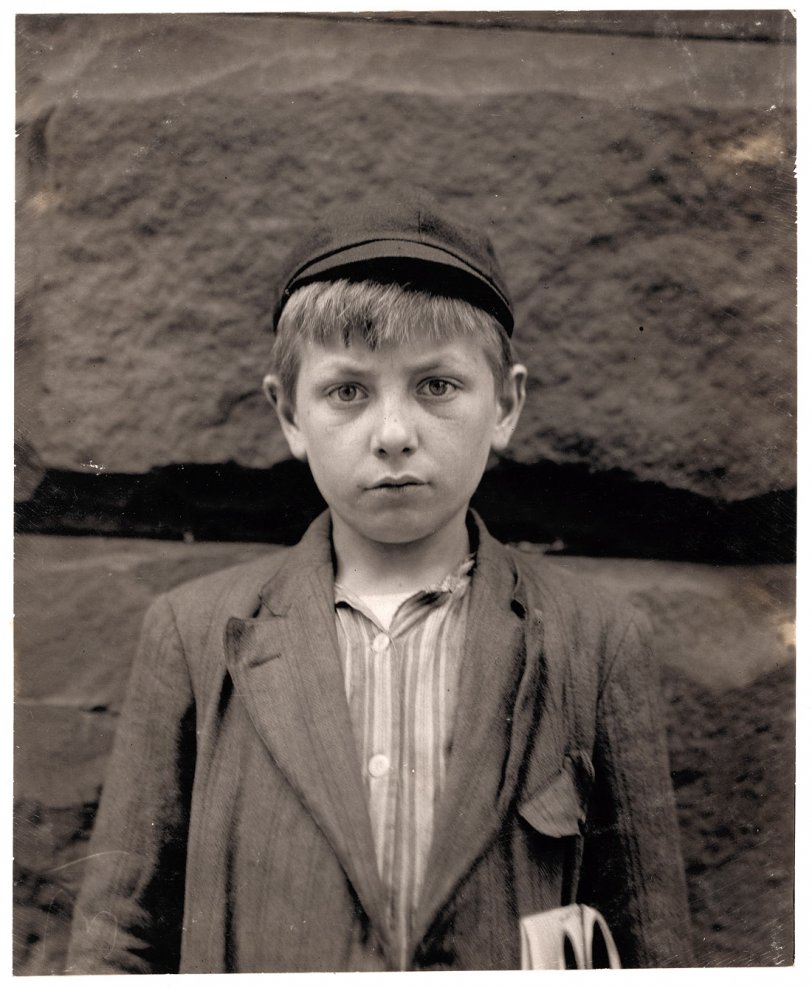 May 1910. Wilmington, Delaware. "Louis Birch, 4th &amp; Pine Streets. Newsboy, 12 years of age. Just started selling. Made 10 cents one day. Father dead. While not under any compulsion to sell papers, Louis, of his own accord, took it up in order to help support his widowed mother. Louis stays out until 12:30 every night and goes with his brother, Stanley, who is a messenger, on all calls because Stanley is afraid to be out on the street alone at night. Louis is clean, bright and willing. Visits saloons. Don’t smoke. Works 9 hours per day. Gives money to mother." Photograph by Lewis Wickes Hine. View full size.
