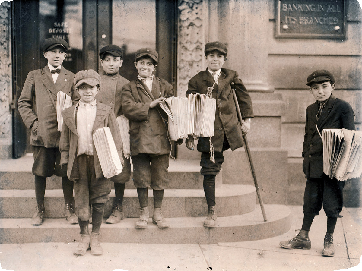 "3 p.m. Some of the boys at a busy trolley junction in Jersey City. Three brothers, Salvatore, 9 yrs. (in front), Joseph, 11 yrs. (cripple), Lewis, 13 yrs. (between these two). 'We would be murdered if we shot craps.' Boy at left sold me pair of dice for 2 cents." November 1912. Photograph by Lewis Wickes Hine. View full size.