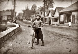 Waco, Texas. November 1913. Isaac Boyett: "I'm de whole show." The twelve-year-old proprietor, manager and messenger of the Club Messenger Service, 402 Austin Street. The photo shows him in the heart of the Red Light district where he was delivering messages as he does several times a day. Said he knows the houses and some of the inmates. Has been doing this for one year, working until 9:30 P.M. Saturdays. Not so late on other nights. Makes from six to ten dollars a week. View full size. Photograph by Lewis Wickes Hine. (Shorpynote: Isaac was born March 20, 1901, and died in May 1966 in Waco.)
