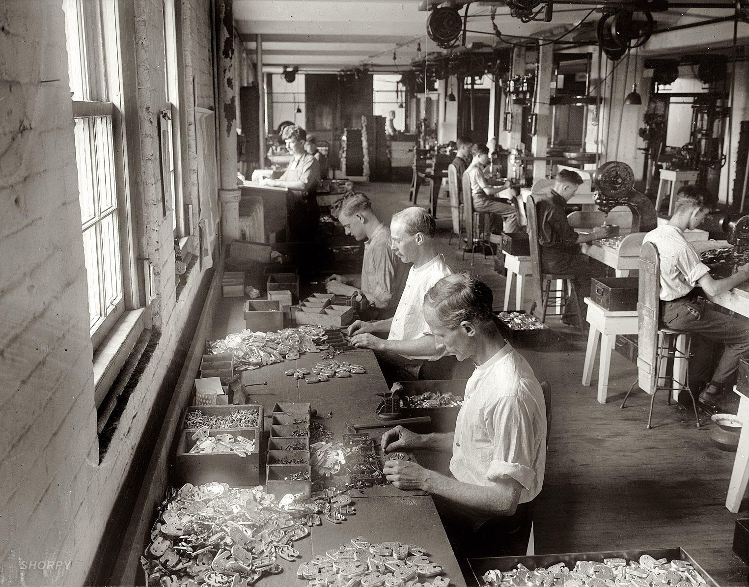 An uncaptioned circa 1915 photo showing the assembly of what look like locks or latches inscribed "U.S. MAIL." Like any progressive workplace, it's equipped with spittoons. Harris & Ewing Collection glass negative. View full size. Update: These are "L.A. locks" being assembled at the Post Office Department's Mail Equipment Shops, 2135 Fifth Street N.E. See the comments for details.