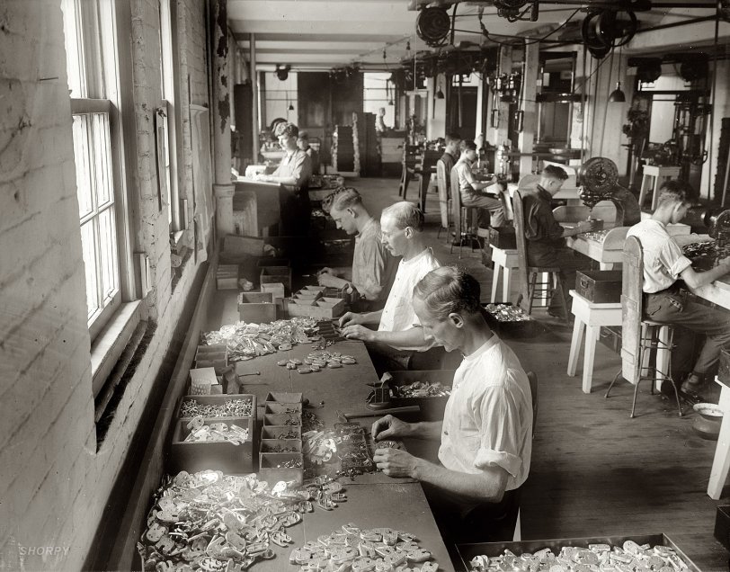 An uncaptioned circa 1915 photo showing the assembly of what look like locks or latches inscribed "U.S. MAIL." Like any progressive workplace, it's equipped with spittoons. Harris &amp; Ewing Collection glass negative. View full size. Update: These are "L.A. locks" being assembled at the Post Office Department's Mail Equipment Shops, 2135 Fifth Street N.E. See the comments for details.
