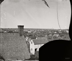 December 1864. "Slabtown. Hampton, Virginia." One of two views of Hampton's slave refugee camps built during the Civil War. The dooryards and various blurry figures moving about in this broken glass negative afford a rare glimpse of life in the mid-19th century. Photographer unknown. View full size.
