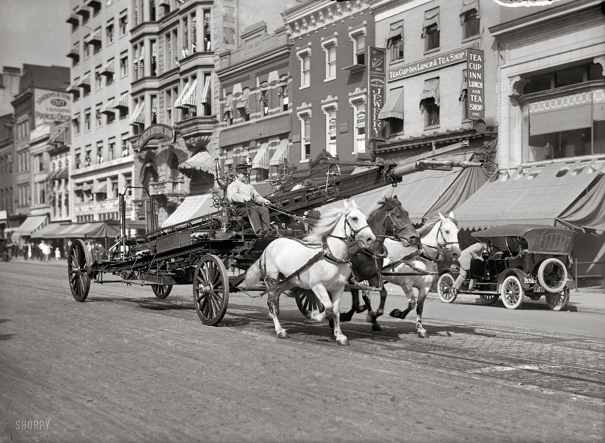 Washington, D.C., circa 1914. "Three-horse team pulling water tower." A fire truck racing past the Tea Cup Inn on F Street. Harris & Ewing. View full size.