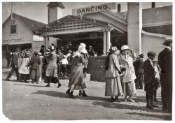 June 1916. Sandy Beach near Fall River, Massachusetts. "Two girls in foreground about 15. Mr. Tebbutt says dance hall bad conditions. Penny picture machine attracting crowds." View full size. Photograph by Lewis Wickes Hine.
Well, maybe or maybe not Fall River was a fishing and mill city in those days; it wasn't high-toned and sophisticated like New York. I'm not sure what "bad conditions" Mr. Tebbutt was referring to (leaving used chewing gum on the arm rests instead of underneath the benches?) but there would only be so much disapproved social behavior from the teen set that the tight, overwhelmingly Roman Catholic, Fall River culture would tolerate before the whip would come cracking down. Generally, there would be only two or three degrees between the ticket-taker and the kids' parents. That wouldn't leave much wiggle-room for shenanigans. 
(The Gallery, Kids, Lewis Hine)
