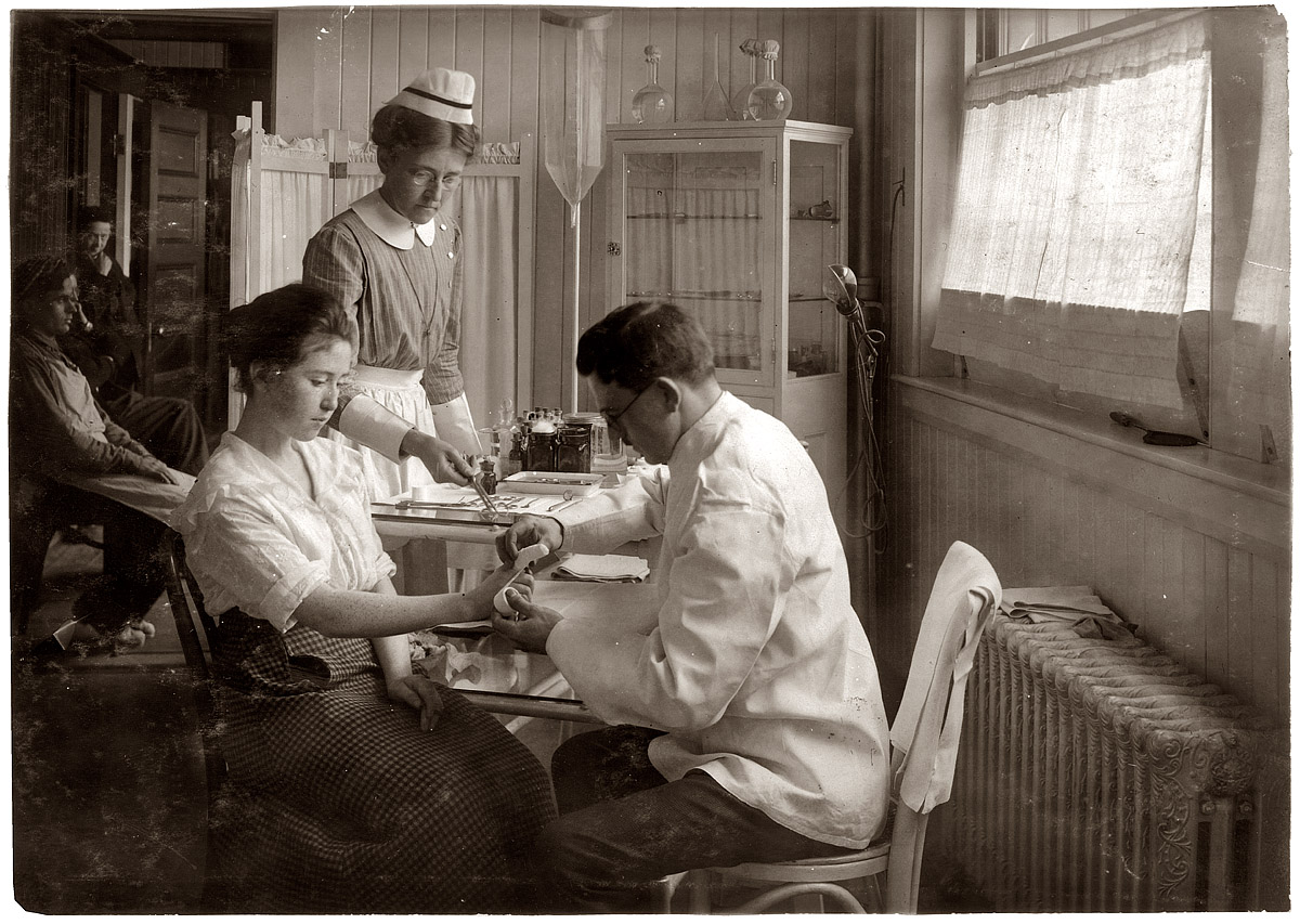 February 1, 1917. An injured finger gets bandaged in the infirmary of the Hood Rubber Co. in Cambridge, Mass. View full size. Photo by Lewis Wickes Hine.