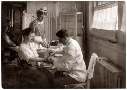 February 1, 1917. An injured finger gets bandaged in the infirmary of the Hood Rubber Co. in Cambridge, Mass. View full size. Photo by Lewis Wickes Hine.
The 1917 infirmaryActually, I'm impressed by a company that actually had an infirmary in 1917 (mine doesn't to this day), and at least a doctorish-looking person to tend it.
Apropos of nothing in particular, the New York Times reported 6/21/1914 that a man claiming to have invented a superior method for producing rubber boots charged that Hood Rubber had had him confined to a psychiatric institution for over three years.  Outcome of the scheduled hearing seems not to have been reported.
(The Gallery, Lewis Hine)