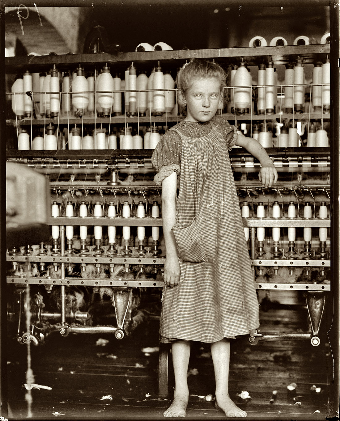 February 1910. Addie Card, 12 years old, anemic little spinner in North Pownal Cotton Mill, Vermont. Girls in mill say she is ten years. She admitted to me she was twelve; that she started during school vacation and would "stay." View full size. Photograph and caption by Lewis Wickes Hine.