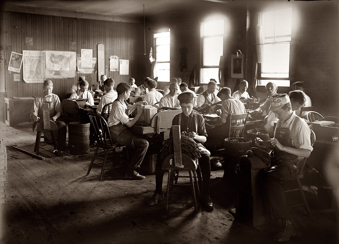 August 1908. Col. Maduro cigar factory in Indianapolis, Indiana. View full size. Photo by Lewis Wickes Hine. Note Celery Cola cap worn by boy on the right.