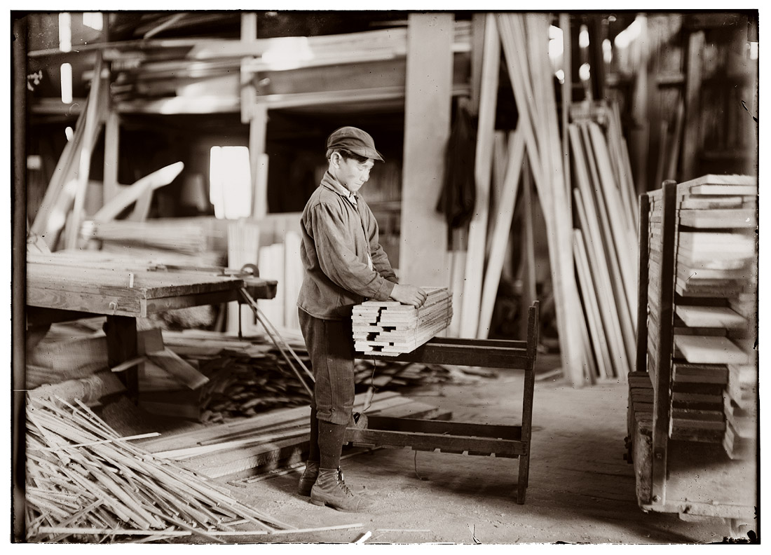 "Boy probably about 13 years old, tying strips which he has taken away from the planer." Schultze Waltum Planing Mill at Evansville, Indiana. October 1908. View full size. Photograph by Lewis Wickes Hine.