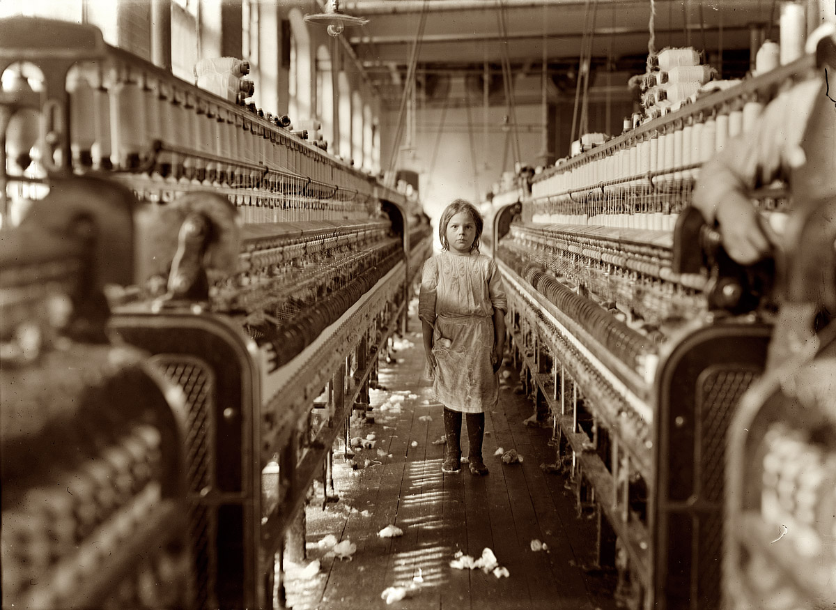 December 3, 1908. "A little spinner in the Mollahan Mills, Newberry, S.C. She was tending her 'sides' like a veteran, but after I took the photo, the overseer came up and said in an apologetic tone that was pathetic, 'She just happened in.' Then a moment later he repeated the information. The mills appear to be full of youngsters that 'just happened in,' or are 'helping sister.' Witness Sara R. Hine." View full size. Photograph by Lewis Wickes Hine.
