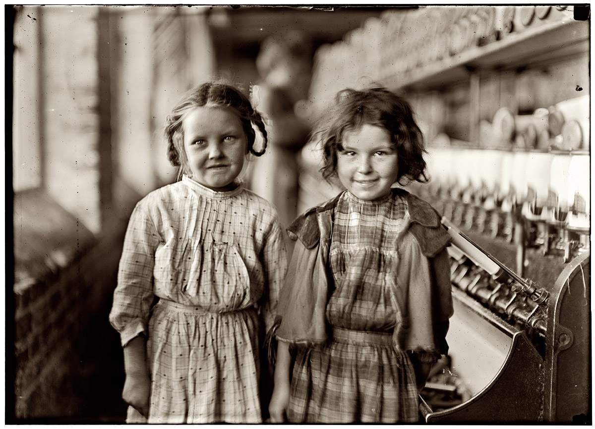 January 1909. Two of the "helpers" in the Tifton Cotton Mill at Tifton, Georgia. They work regularly. View full size. Photo and caption by Lewis Wickes Hine.