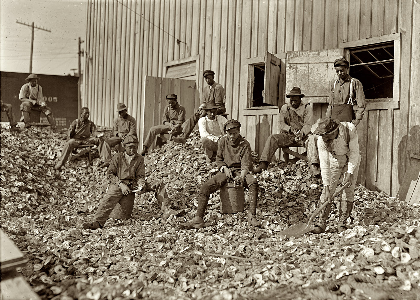 January 1909. "Oyster shuckers at Apalachicola, Florida. This work is carried on by many young boys during busy seasons. This is a dull year so only a few youngsters were in evidence." View full size. Photograph by Lewis Wickes Hine.