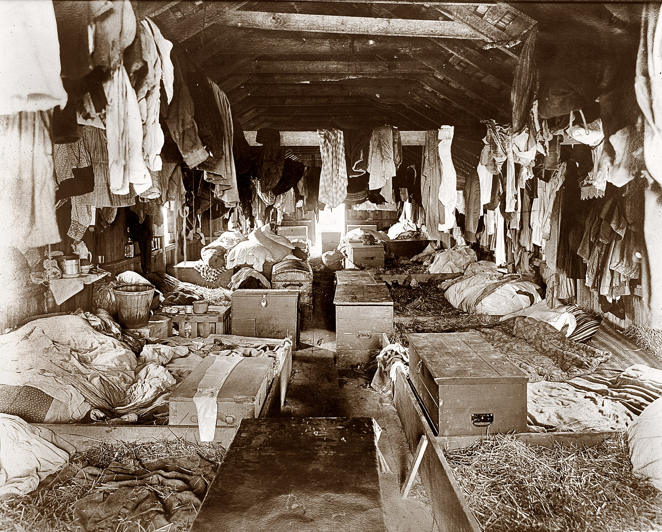 Circa 1909. Straw beds and footlockers in shack occupied by berry pickers. Anne Arundel County, Maryland. View full size. Photograph by Lewis Wickes Hine.