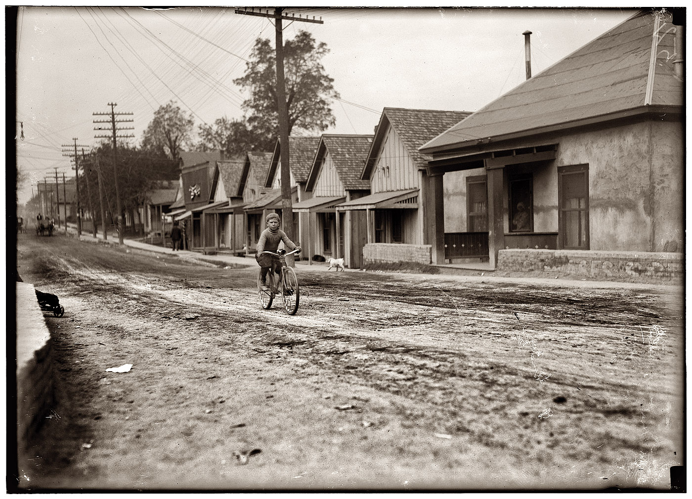 A long shot of 12-year-old Isaac Boyett in the Red Light District of Waco. View full size. Scanned from glass-plate negative. Photograph by Lewis Wickes Hine.
