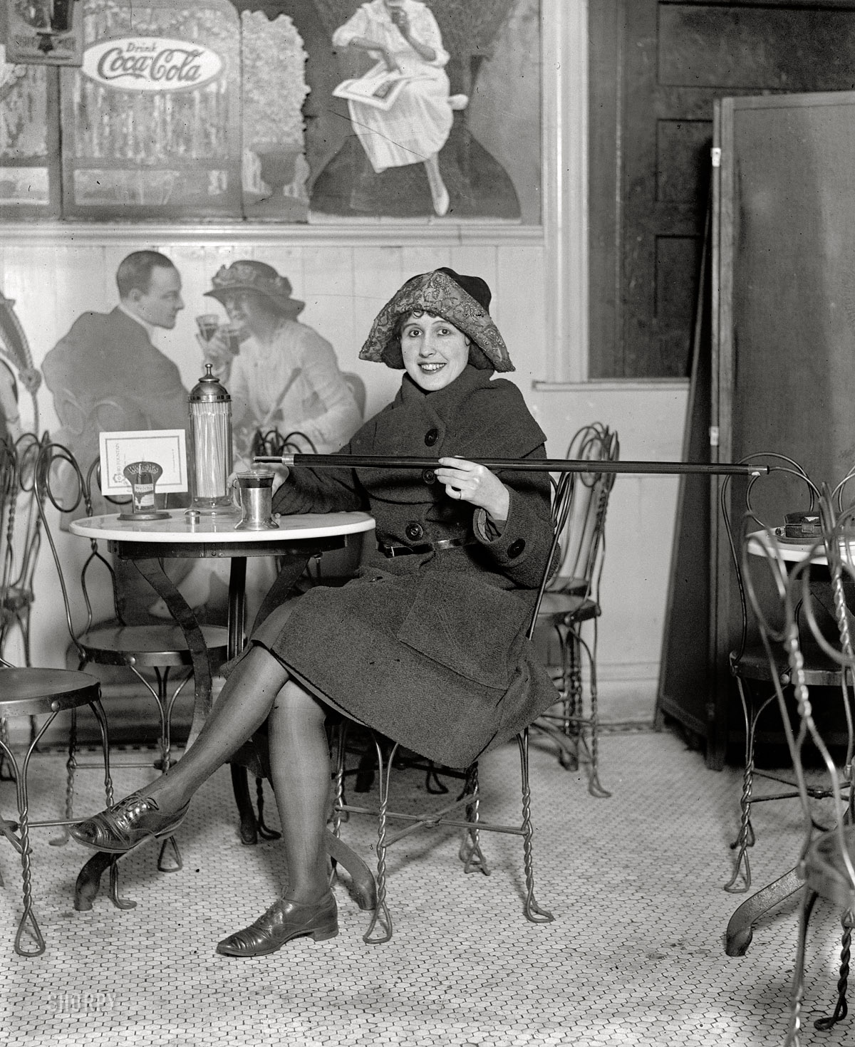 February 13, 1922. Washington, D.C. "Unidentified woman." Demonstrating an ingenious Prohibition-era fashion accessory, the cane-flask. View full size.