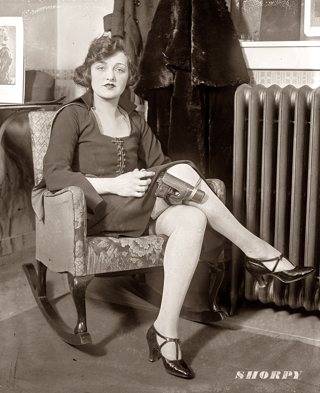 " 'Safety first' is the motto of Miss Mary Jayne of Keith's circuit. Mary Jayne, seated in rocking chair with pistol strapped to her knee, claiming exemption from concealed weapon regulation by saying her thirty-two isn't a concealed weapon in these days of knee-length skirts." National Photo Company Collection, February 14, 1922. View full size. The Keith Circuit was a chain of vaudeville theaters that eventually transitioned to motion pictures.