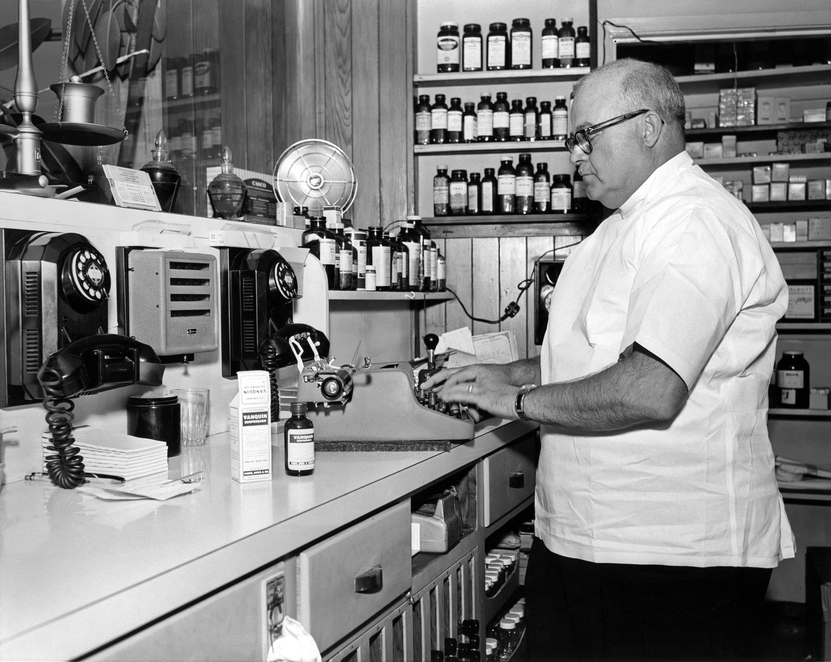 I purchased this 8 x 10 print at the swap meet. On the back is printed:

Mr. Cliff McCorkle, proprietor and pharmacist of the 101 Broadway Pharmacy, Richmond, Calif., preparing a prescription. 5 November 1957. Photographer: Pfc. Barbara A. Warner, Sixth US Army Photo Lab, Presidio of San Francisco, Calif. Official US Army photograph. View full size.