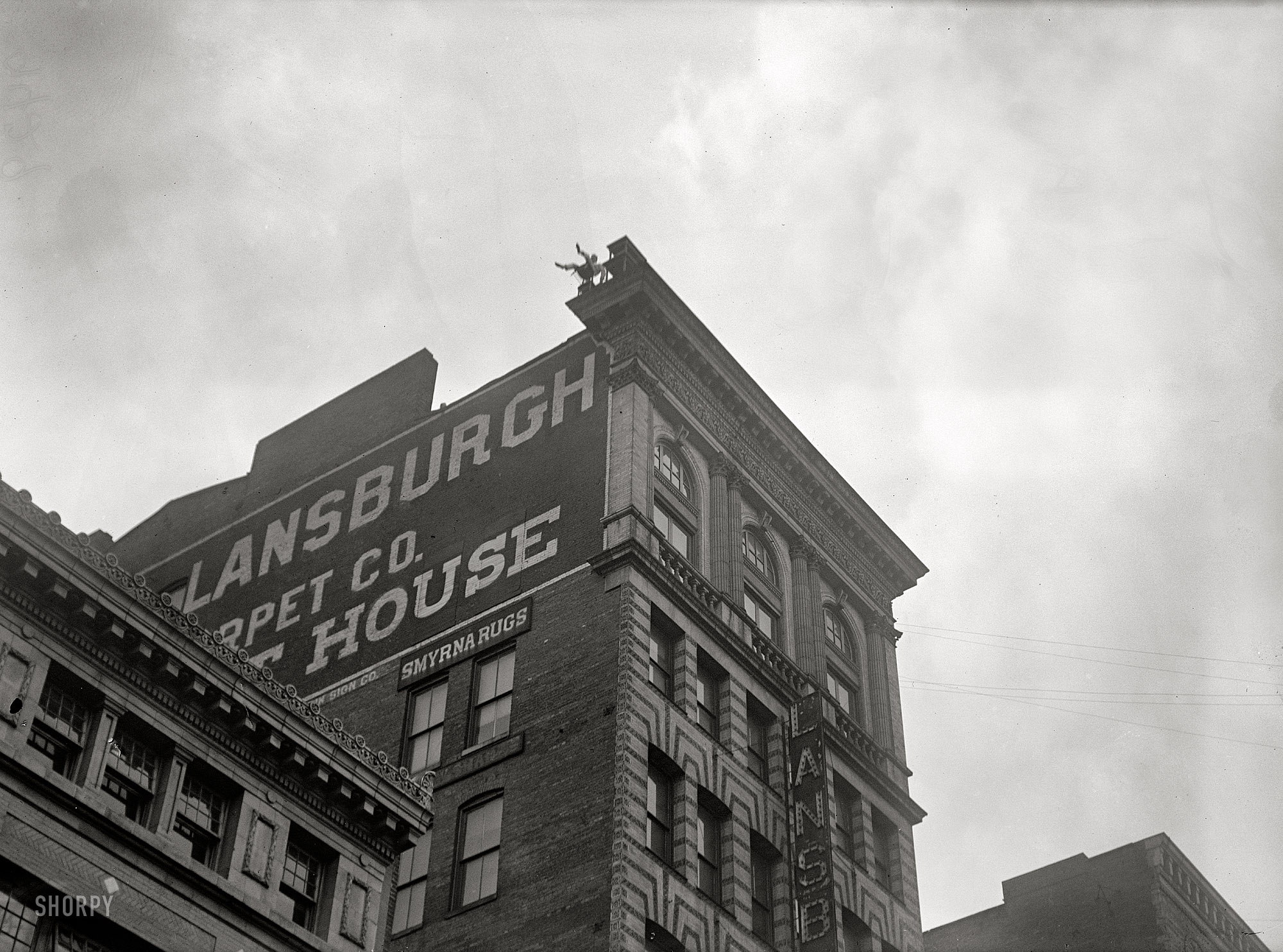 Everything must go! Mr. Reynolds again up on the roof of the Lansburgh furniture store in 1917. Harris & Ewing Collection glass negative. View full size.