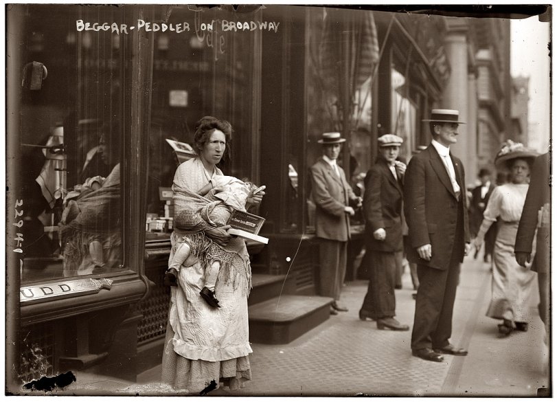 Well-dressed pedestrians glance at a "beggar-peddler" holding a small child and a box of Wrigley's Spearmint Gum on Broadway, in New York City. View full size. 5x7 glass negative, George Grantham Bain Collection.
