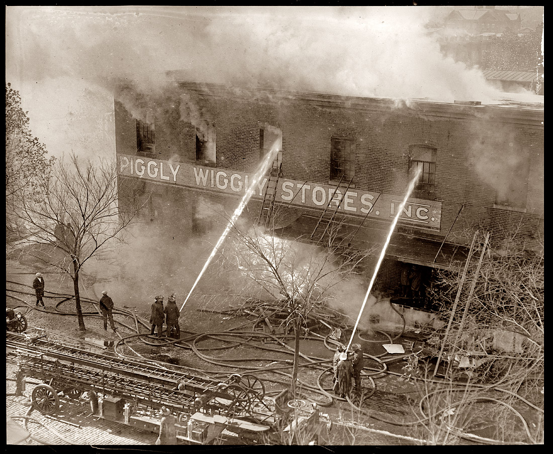 November 9, 1923. Firemen extinguishing a blaze at the Piggly Wiggly, location not specified. View full size. 4x5 glass negative, National Photo Co. Collection.