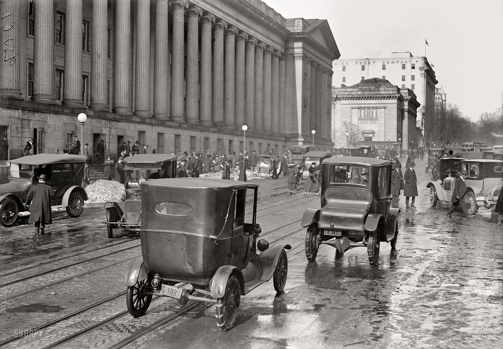 Washington, D.C., in 1918. "Fifteenth Street." Motoring past the Treasury Building with chains on. Harris & Ewing Collection glass negative. View full size.